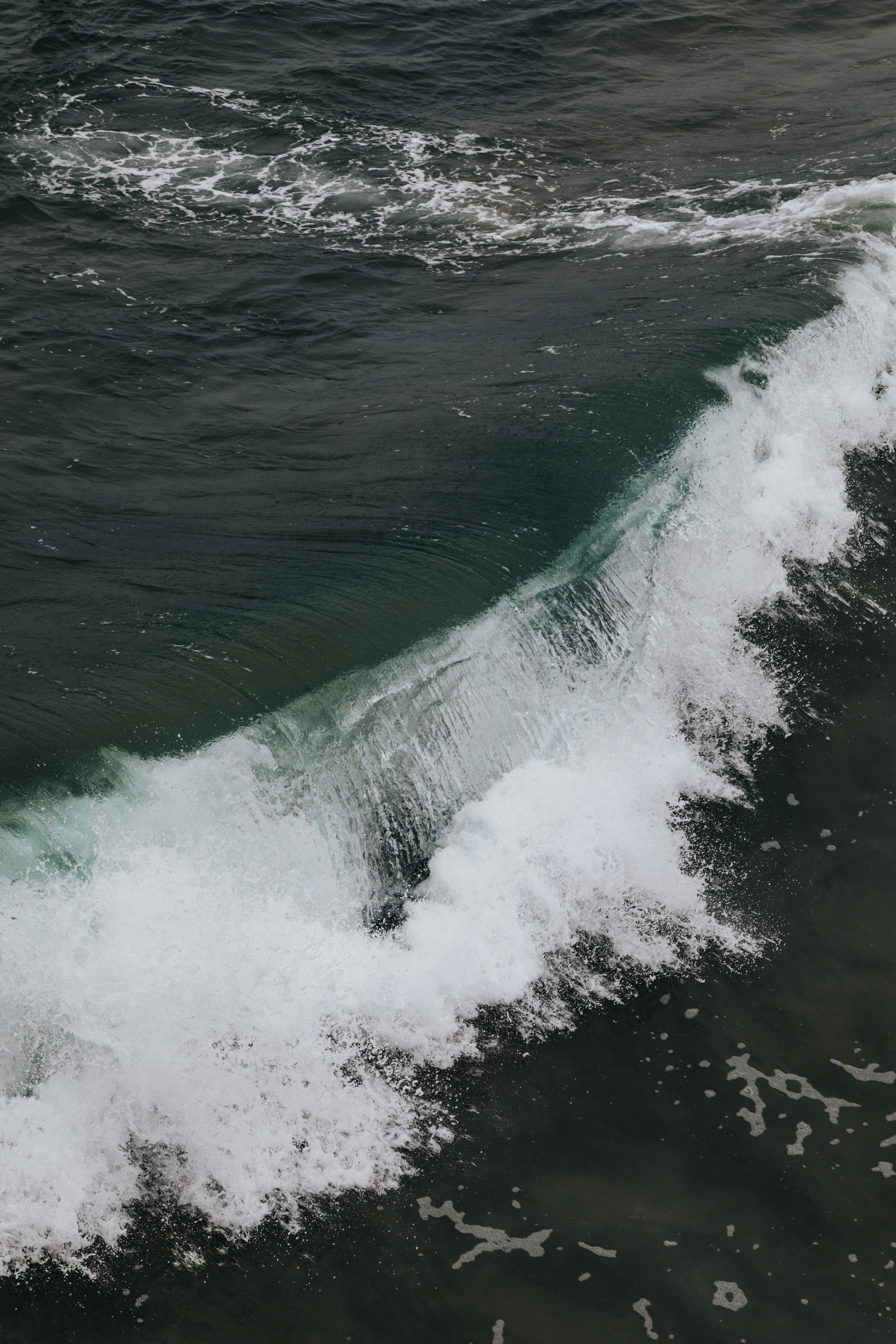 ocean waves crashing on shore during daytime